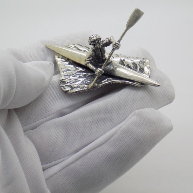 This vintage silver decorative object depicts a detailed canoe rower figurine, crafted as a sports curiosity or cabinet...