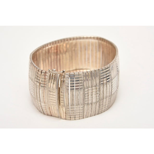 This lovely vintage sterling silver cuff bracelet is hallmarked. It has a weave of linear silver in design form. Light in...