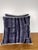 A striking pair of decorative pillows crafted from richly patterned batik textiles, featuring deep indigo and charcoal...