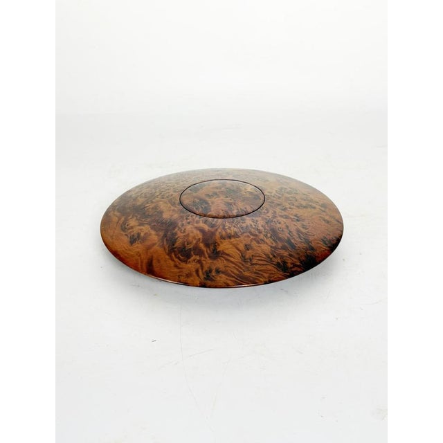 An elegant round wooden box dating from the 1970s, characterized by a superb veneer with intricate and contrasting grain....