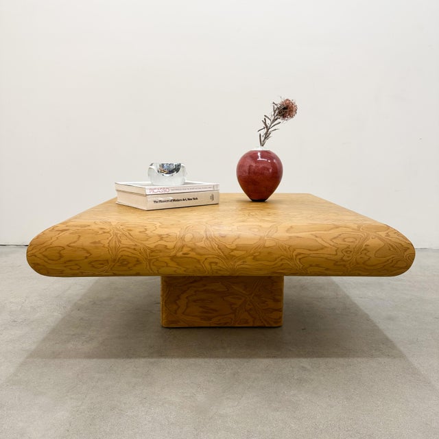 This vintage Postmodern coffee table features a distinctive bullnose edge and a warm golden tone that highlights the sleek...