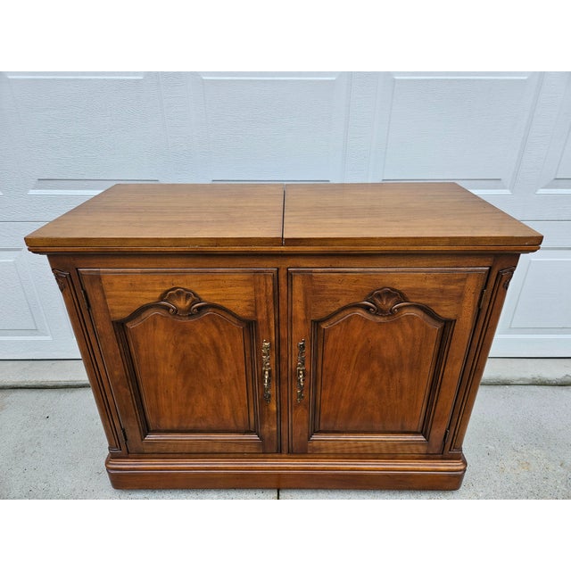 This well-crafted flip top server on casters is by Kindel Furniture. It features locking cabinet doors (two keys...