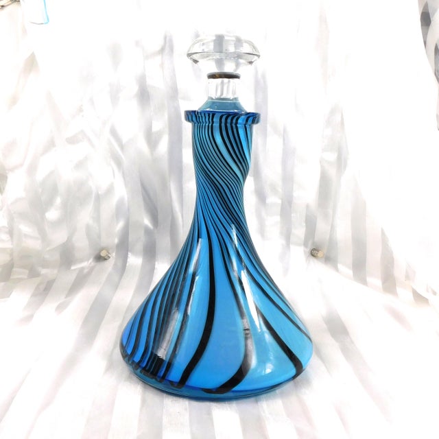 This is a blue wide bottom decanter with black stripes and a clear stopper that does not fit. When the stopper sits...