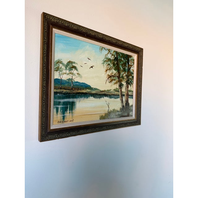 Beautiful 1980’s vintage tropical landscape oil painting on board signed “Rockwell Kent.” This serene composition depicts...