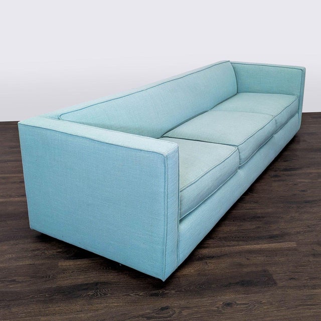 This CB2 3-seat sofa features a sleek, modern design with clean lines and a light blue fabric. It offers comfortable,...