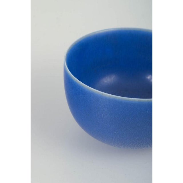 Stoneware bowl with a deep matte blue glaze, shaped in a simple and harmonious rounded form. Signed on the underside:...