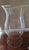 Single round clear glass candle hurricane shade with curved sides with etched fern design. The fern etching begins at the...