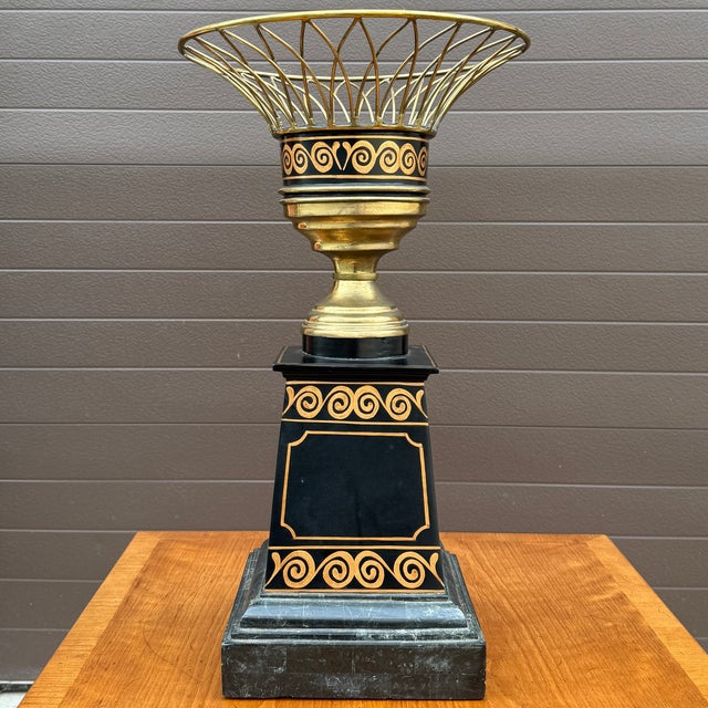 An early 21st century Maitland Smith Hollywood Regency brass planter with a marble base and black lacquer & gold pedestal....