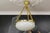 Antique French Louis XVI style white glass, brass, and bronze pendant chandelier from ca. 1920. This stunning French...
