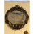Oval shaped wood carved mirror frame with aged mirror featuring a flower motif with silver and walnut finish. Italy.