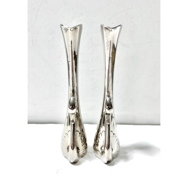 A graceful pair of vintage silverplate bud vases designed as stylized swans, with elongated necks forming the vase...