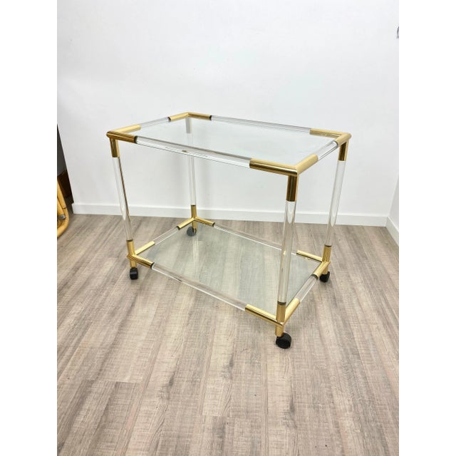 Bar serving cart trolley in acrylic structure and brass details with two glass shelves. Original from Italy, 1960s.