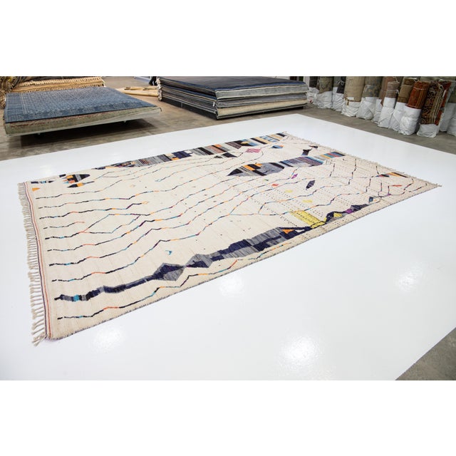 Beautiful moroccan berber style hand-knotted wool rug with an ivory field. This piece has multicolor accents in an all-...