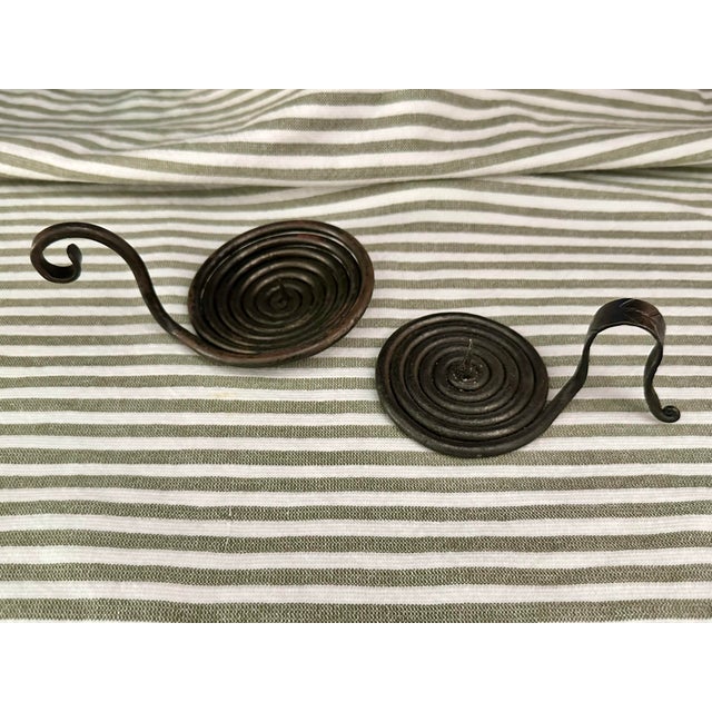 Pair of medieval style spiral candle holders. They are crafted from a single piece of forged iron steel, featuring a...