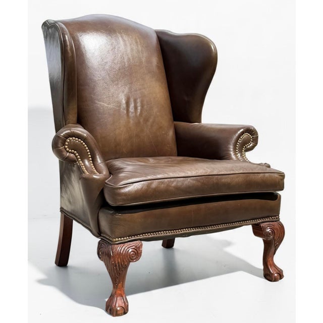 Classic Ethan Allen leather wingback armchair featuring a tall, sculptural back, rolled arms with decorative nailhead...