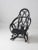 This is an antique Adirondack twig rocking chair. Painted black, the chair features a captivating woven back design...