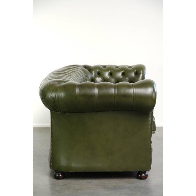 This nice green cowhide leather 2.5-seater Chesterfield sofa has a great timeless look and features loose seat cushions. A...
