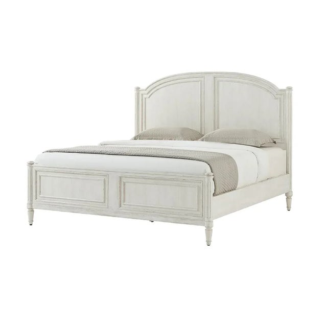 A white washed painted four post king size bed with carved arch panel headboard and paneled footboard with turned posts...