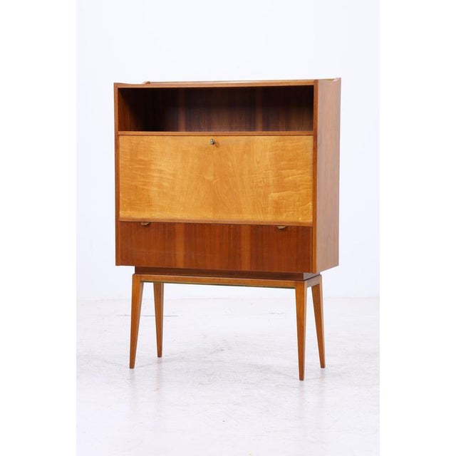 Vintage secretary desk with a clean, compact design and a very well-organized interior. Behind the large writing flap are...