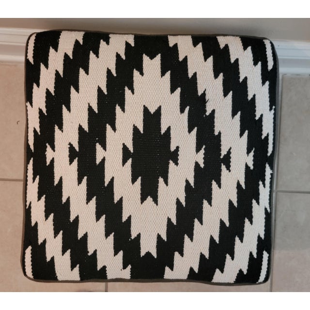 Add a touch of geometric boho with this Southwest or Kilim style footstool with wooden legs and nailhead trim. Measures...