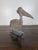 Antique metal weathervane in the shape of a Pelican. The metal has developed a rich patina over time, with a mix of...
