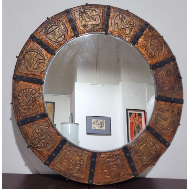 Mirror from the 1970s, covered with a hammered copper sheet and decorated with horoscope motifs, created by the renowned...