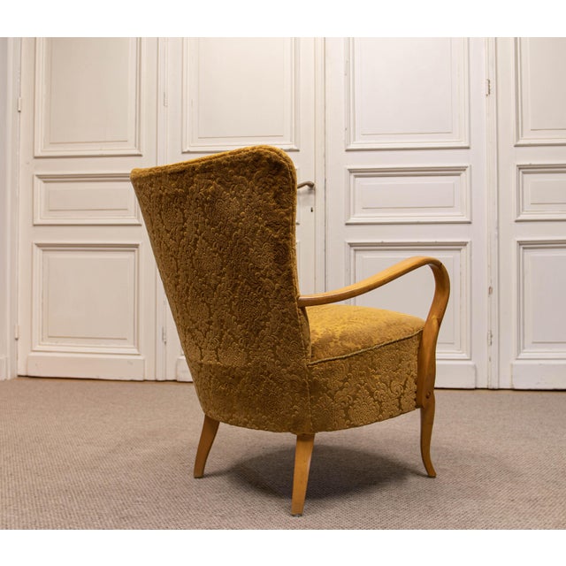 The chair features an elegant and highly sculptural form, with gracefully curved elm armrests and legs that flow...