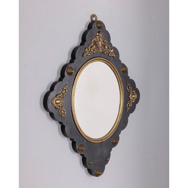 Wall mirror with black wooden frame and gilded bronze decorations, Italian design, early 20th century.