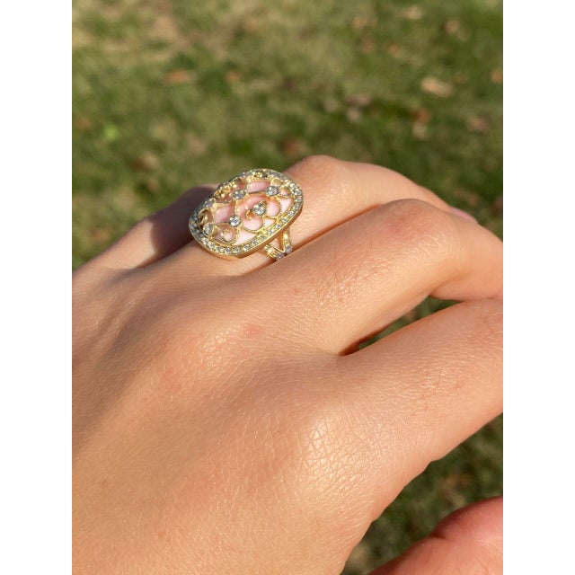 The 154th Avenue: Pink Coral and Natural Diamond Cocktail Ring in Yellow Gold. The ring's focal point is a central round-...