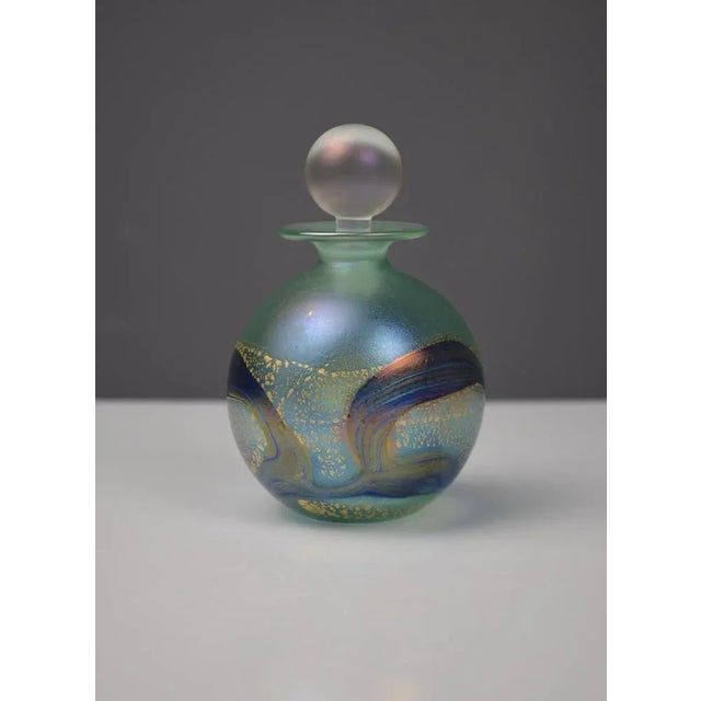 Elegant blown glass perfume bottle by Isle of Wight Studio Glass. The spherical body displays a stunning green and blue...