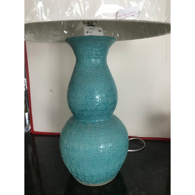 Lovely shade of turquoise/aqua dimpled ceramic lamp with white linen shade. Ceramic matching finial. 31” to top of finial....