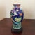 Beautifully painted early 20th Century porcelain vase. Bird and flower design with carved wooden base.