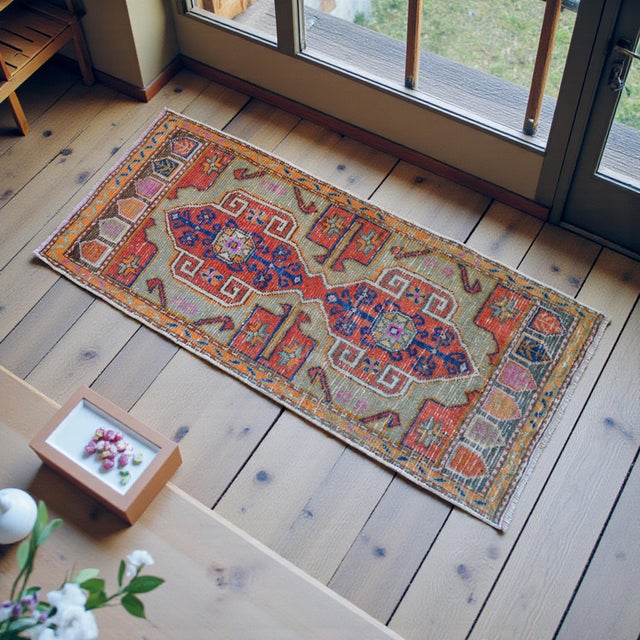 This exquisite hand-knotted mat from the Denizli region features vibrant earthy tones and traditional geometric medallions...