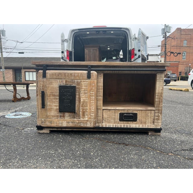 A rugged and stylish industrial media cabinet crafted circa 2010s, featuring a sliding barn-style door, open shelving, and...