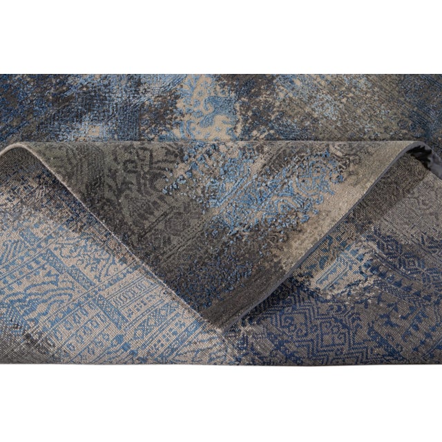 Beautiful modern hand-knotted wool rug. This rug has a blue field with abstract accents of gray and light shades of blue...