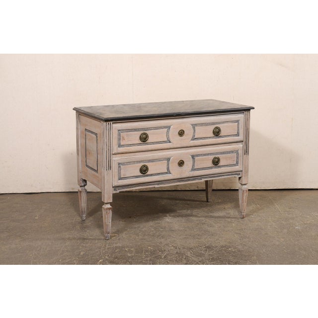 An Italian carved and painted wood raised chest of two drawers from the 18th century. This antique cassettiera (chest of...