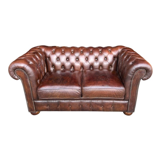 This vintage English Chesterfield sofa has been fully restored and newly dyed in a rich brown tone, bringing new life to...