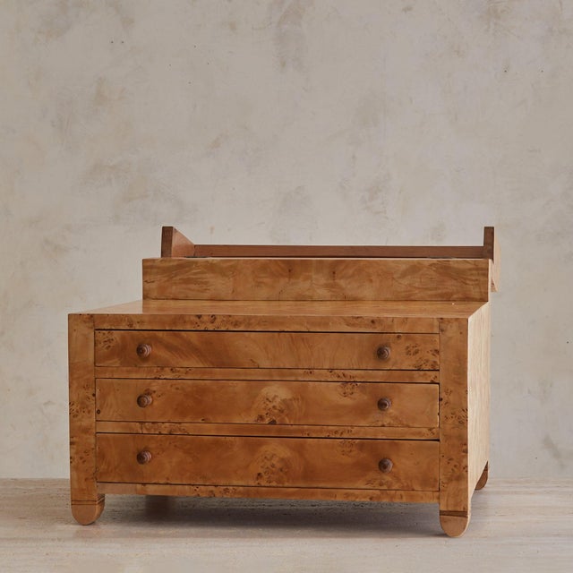 An Italian jewelry chest in honeyed burlwood, crafted in the 1960s. The rectangular form features three smooth-gliding...