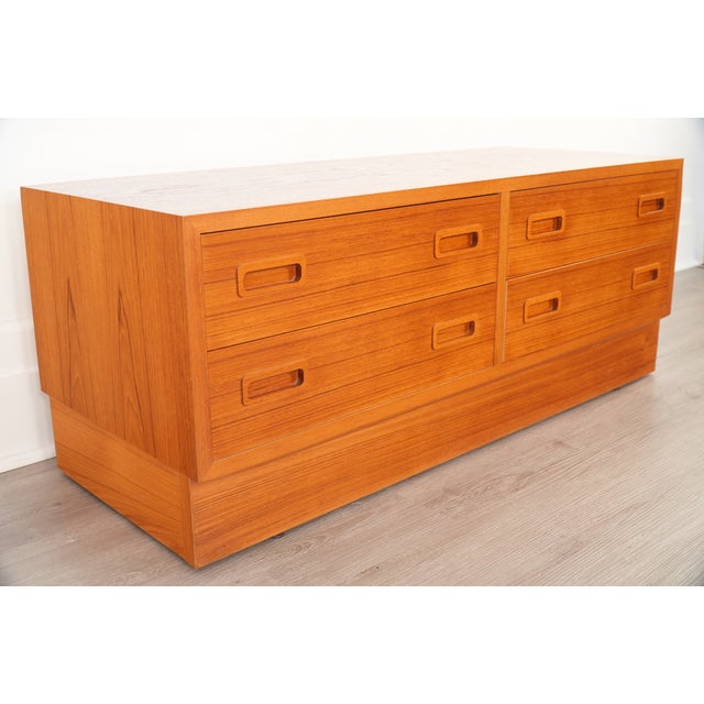This low-profile Danish cabinet by Hundevad features warm teak construction, four dovetailed drawers, and recessed pulls....