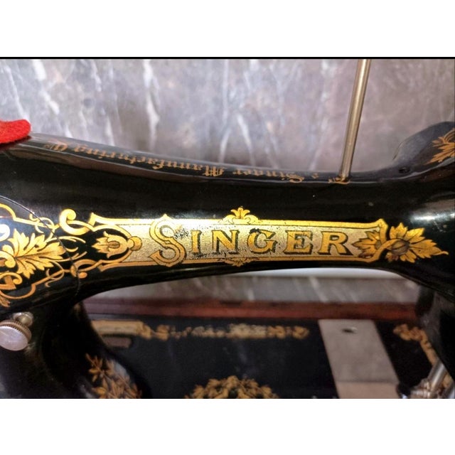 Beautiful antique Singer hand-crank sewing machine presented in its original bentwood wooden case. This classic black...