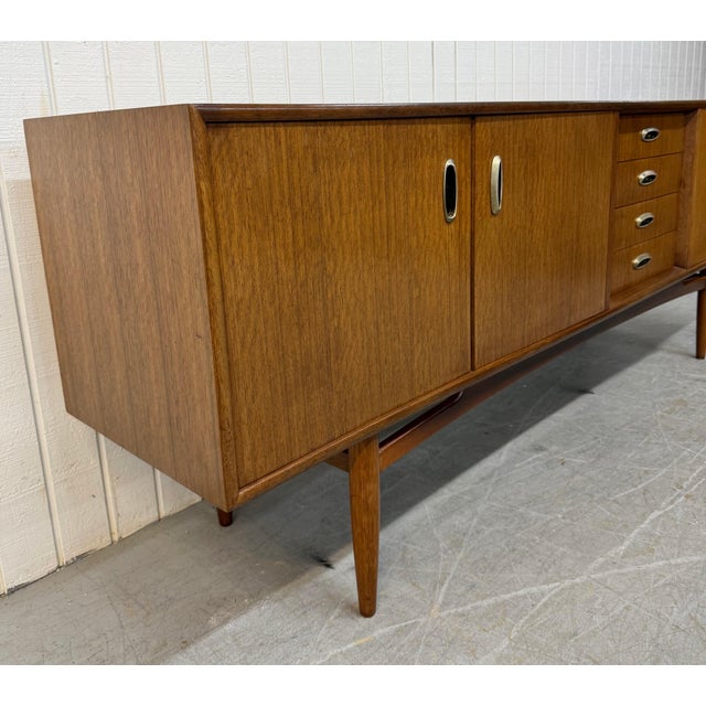 This listing is for a Mid-Century Modern G-Plan Walnut Sideboard. Featuring a straight line design, cabinet doors on the...
