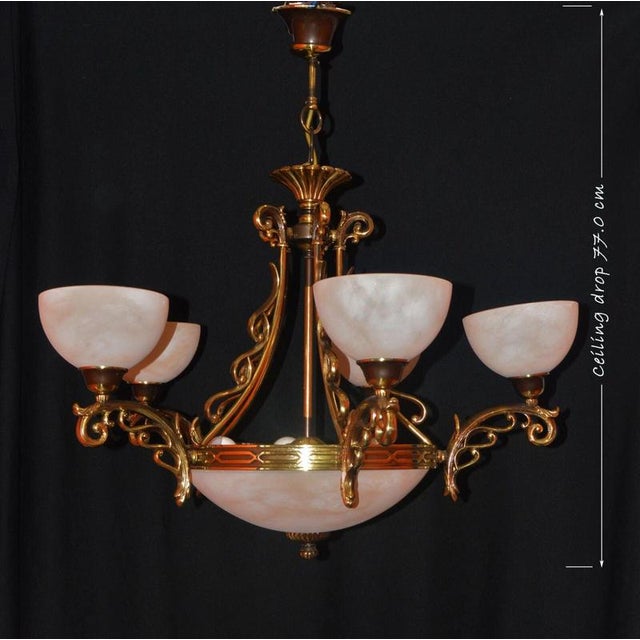 A monumental and highly decorative Art Deco brass and glass chandelier dating to circa 1930, distinguished by its...