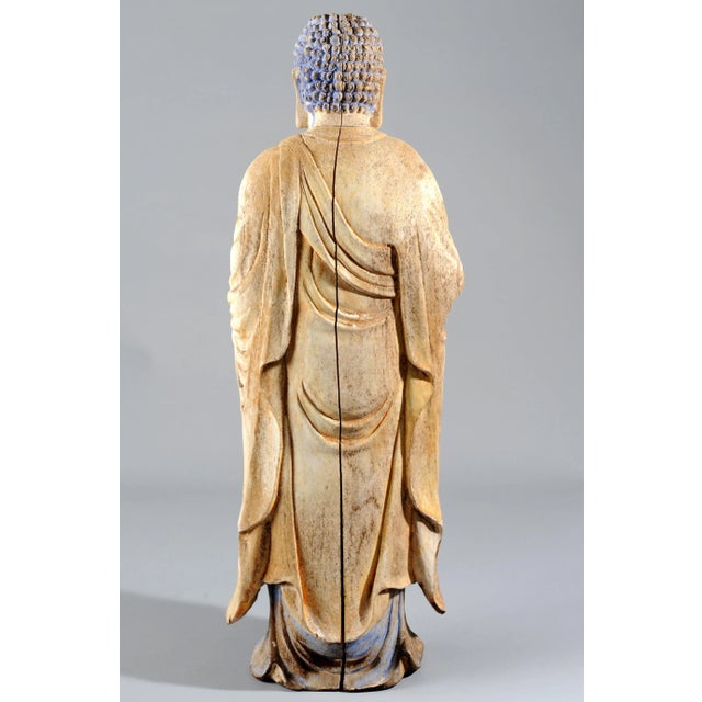 A statue of standing Buddha (Shakyamuni), finely carved out a single block of wood (might be cypress based on the wood...