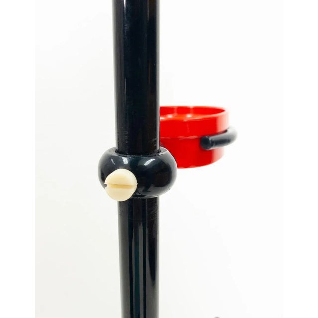 Italian piece from 1982. Metal upright, plastic shoulder piece. Metal top. Plastic imitation marble feet. Signal red...