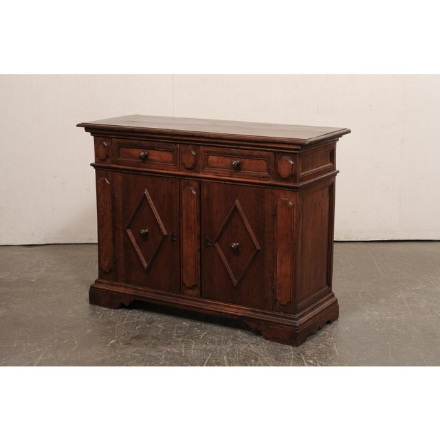 An Italian wooden credenza, with decorative geometric accents, from the mid 19th century. This antique buffet cabinet from...