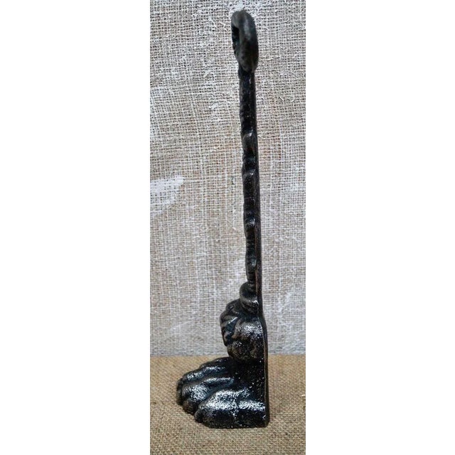 Antique Cast Iron Lion's paw door porter, the door porter have a leaf decorated loop handle, above a shank with fern cast...