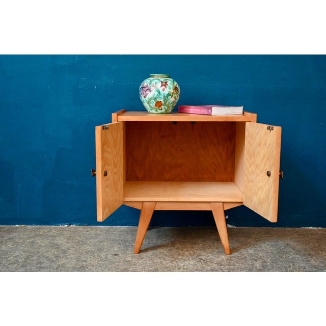 Charming and unique, this small two-door bedside table from the 1950s boasts a slightly rockabilly silhouette! Resting on...