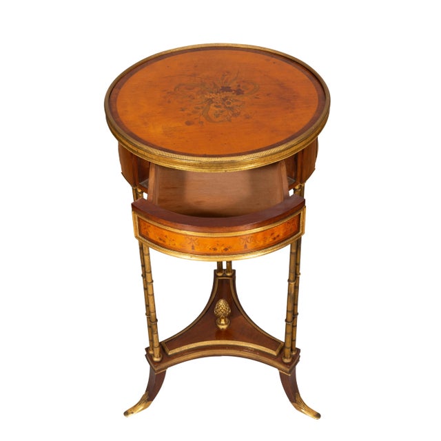 Circular top with central floral spray and rosewood banding and bronze edge, the frieze with a drawer with hidden button...