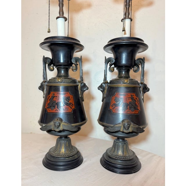Up for sale is a very high quality pair of antique Egyptian Revival figural urn style table lamps. These urns are in the...