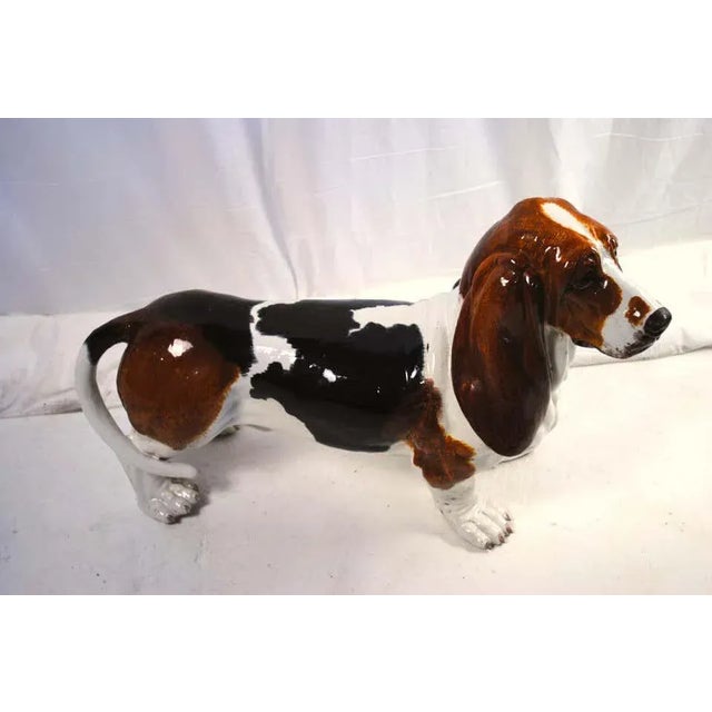 A ceramic figure of a life-size basset hound, dated 1900s. A rear and adorable depiction of a basset hound. Unmarked but...